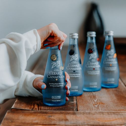 Clearly Canadian - Four 325ml Bottles of All Four Flavours On a Rock by a Mountain Stream