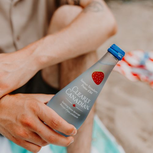 Clearly Canadian - Four 325ml Bottles of All Four Flavours On a Rock by a Mountain Stream