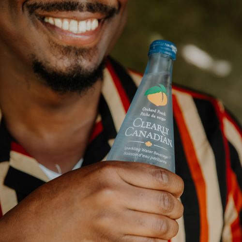 Clearly Canadian - Four 325ml Bottles of All Four Flavours On a Rock by a Mountain Stream